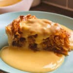 A slice of retro cornflake tart with a golden syrup glaze, served with a side of creamy custard.