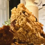 Homemade chewy granola bars with cranberries, raisins, and almond flakes, cut into squares.